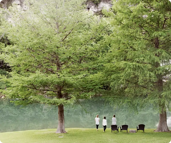 Allison, Kelly, and Marilee walking along a path by a lake with trees in the background